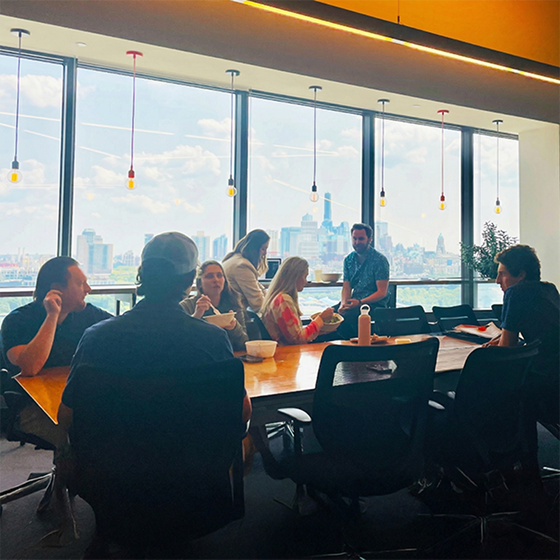 Team members eating lunch at a conference table in the office Team members eating lunch at a conference table in the office